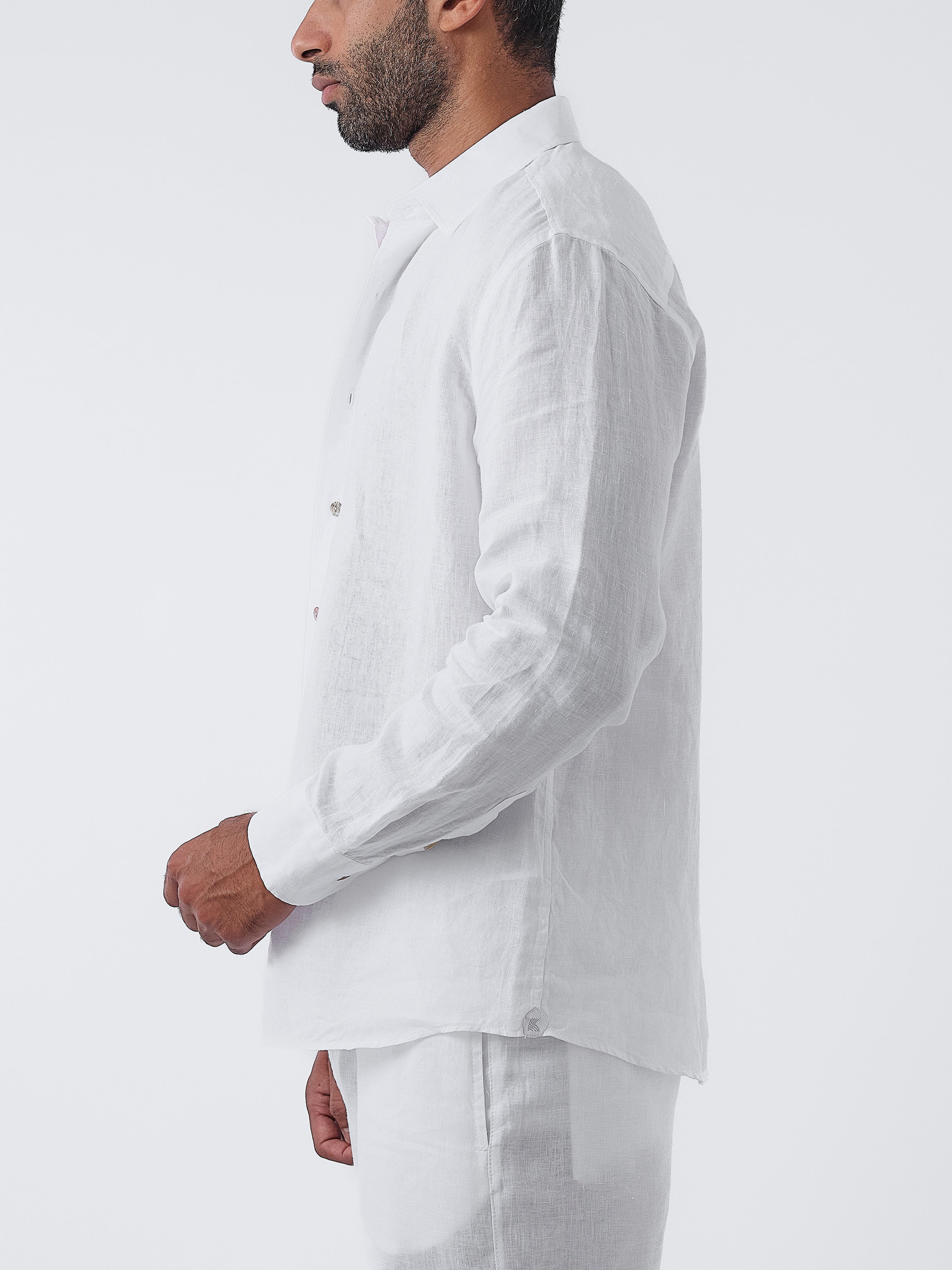 Man wearing a white linen shirt and pants on a white background