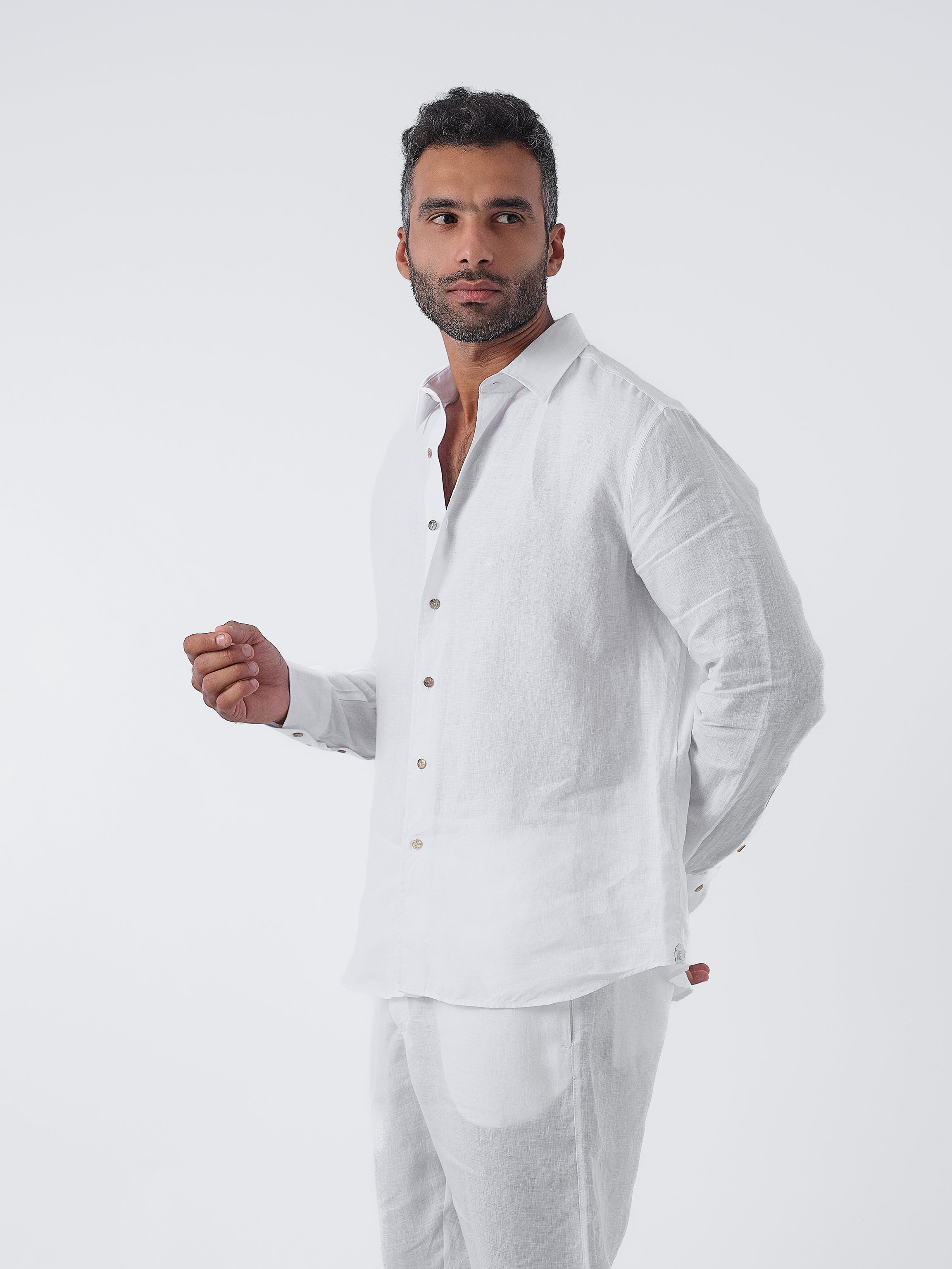 Man wearing a white linen shirt and pants on a white background