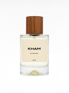 Perfume bottle labeled 'KHAM' with a wooden cap on a white background