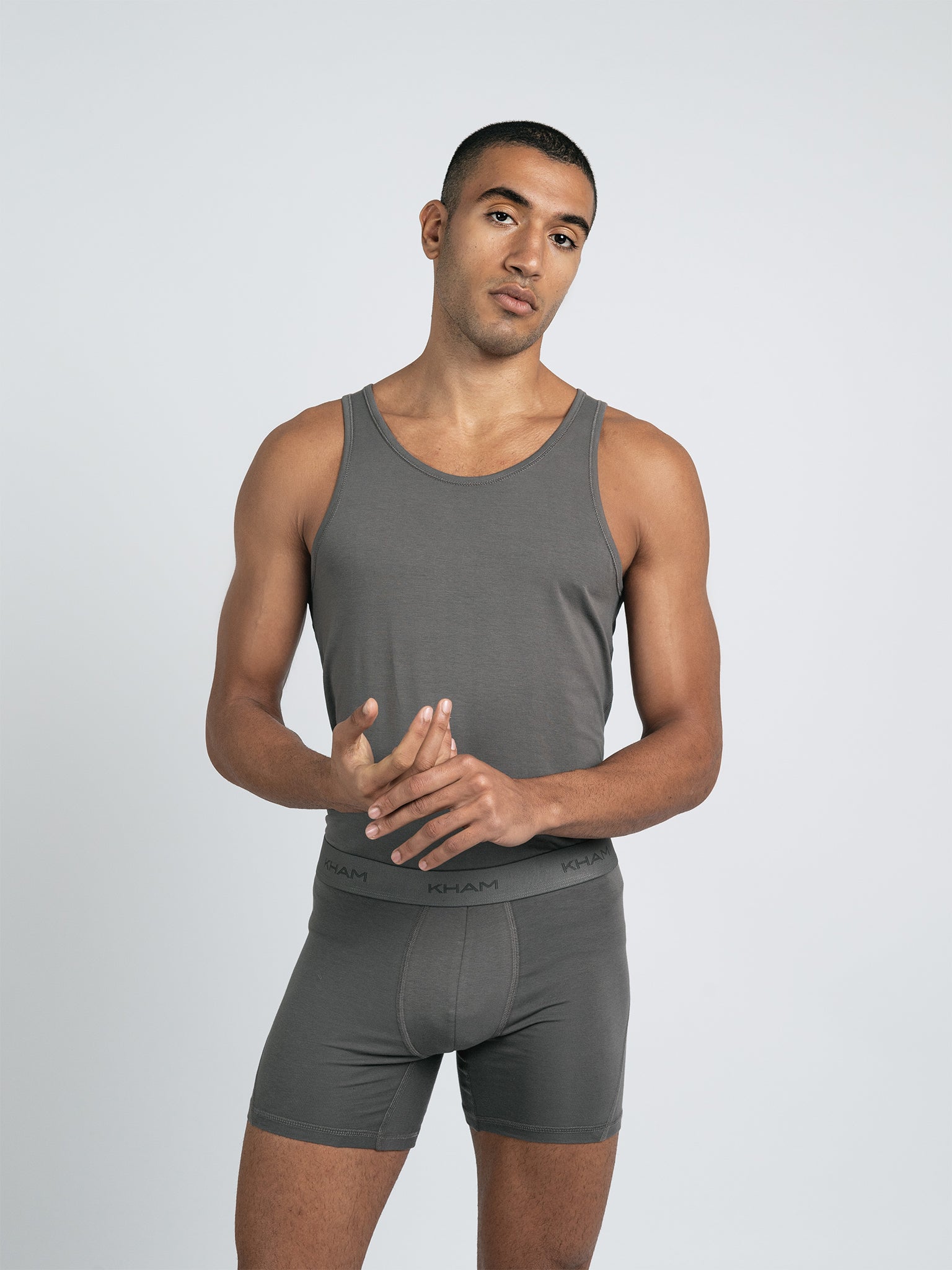 A male model wearing a gray knit tank top with short sleeves.