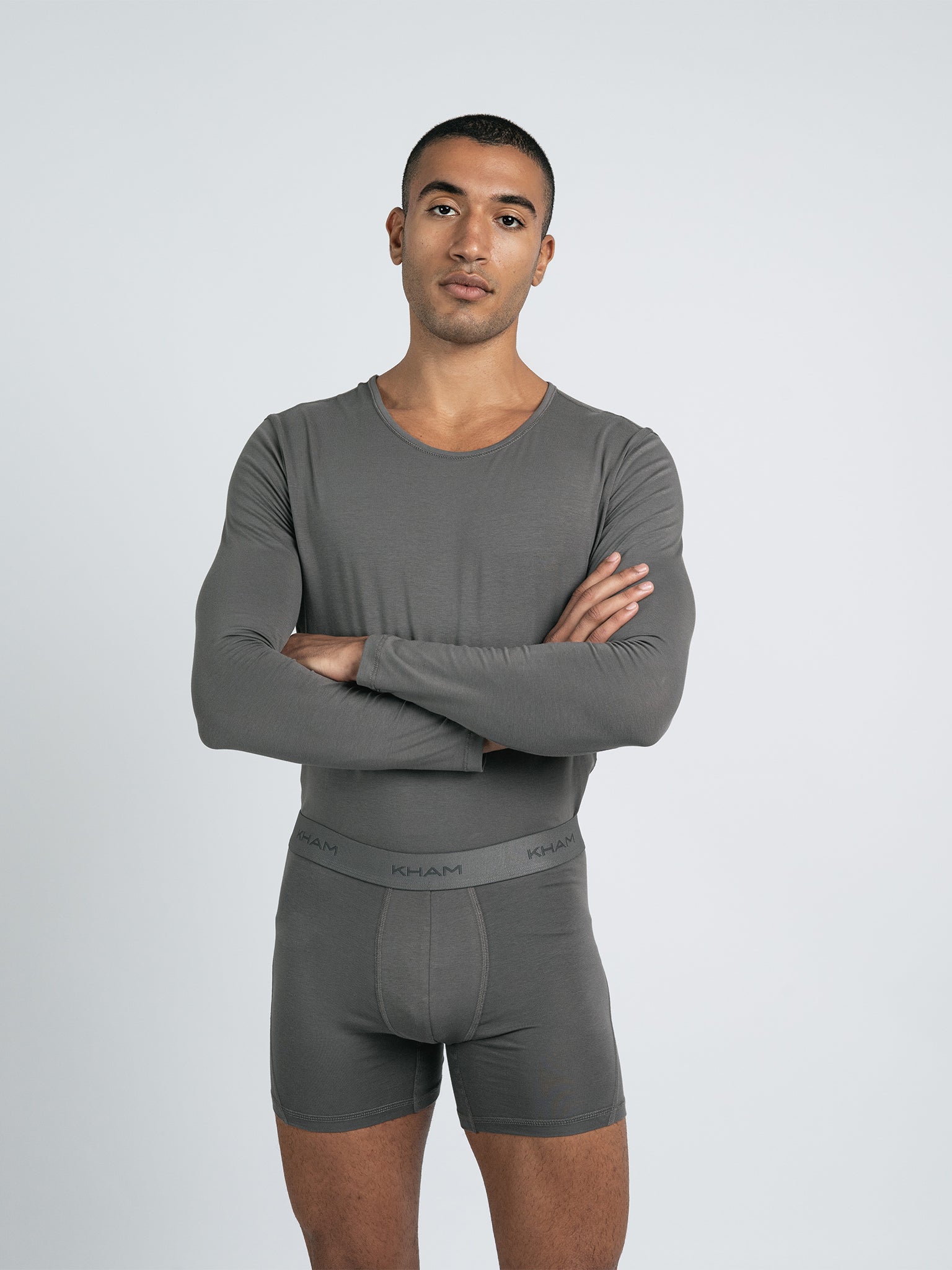 A male model wearing a long sleeve knit crew neck shirt in gray.