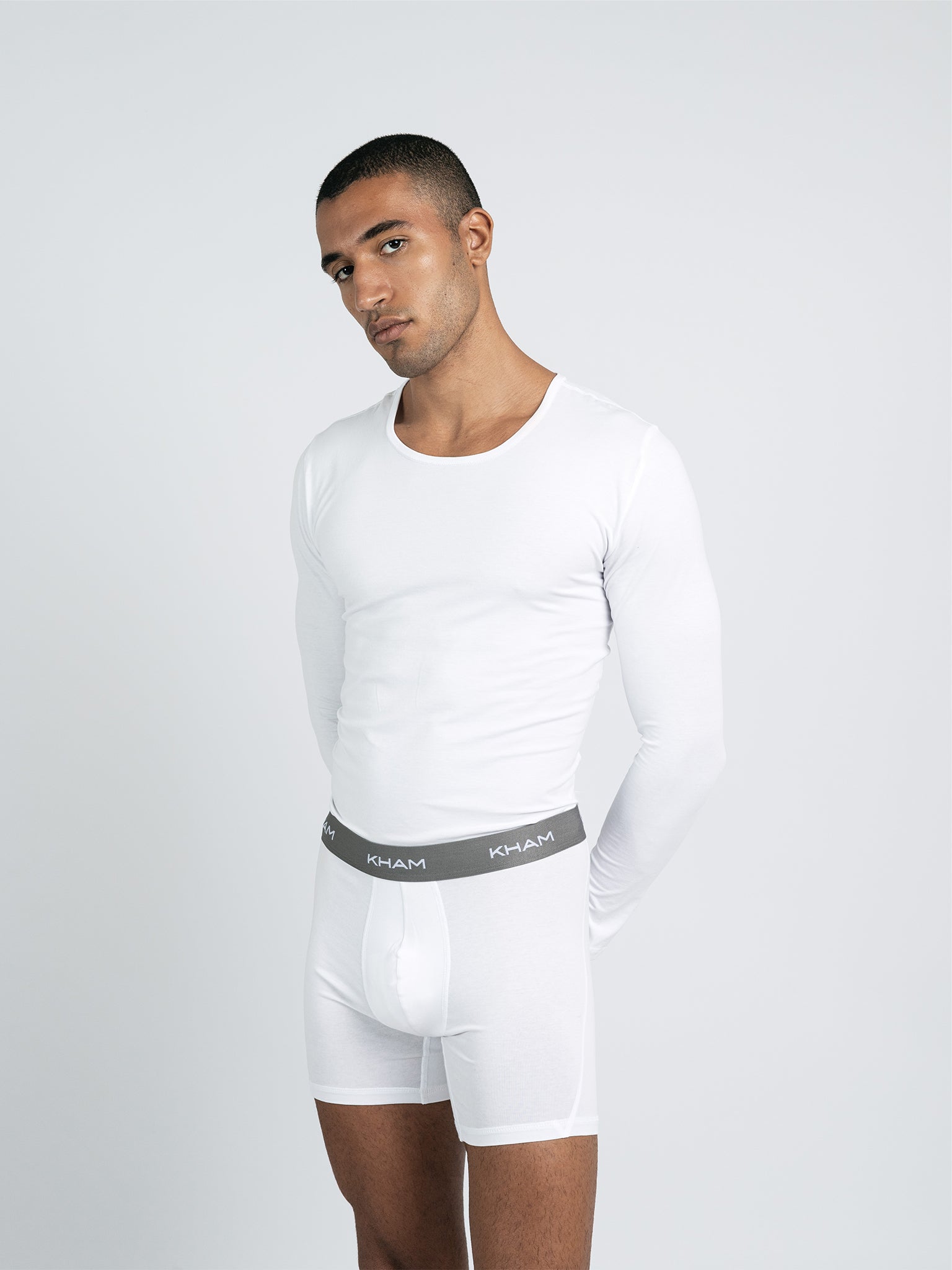 A male model wearing a long sleeve knit crew neck shirt in gray.